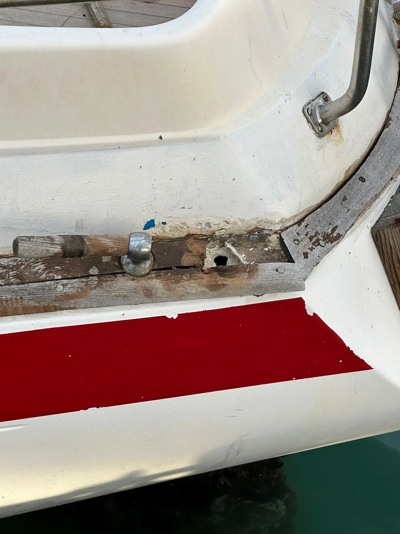 Geschädigtes Boot SANKARA – Heckdeck-Beschlag mit offenliegendem und ausgebrochenem Holz im unmittelbaren Umfeld.