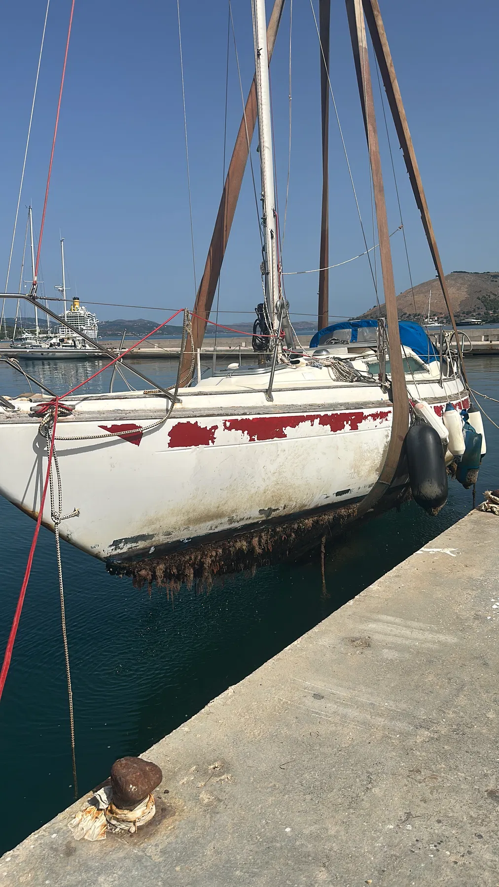 Geschädigtes Boot SANKARA – Rumpf im Hebegurt; Seitenfläche und Unterwasserschiff sind aus kurzer Distanz sichtbar.