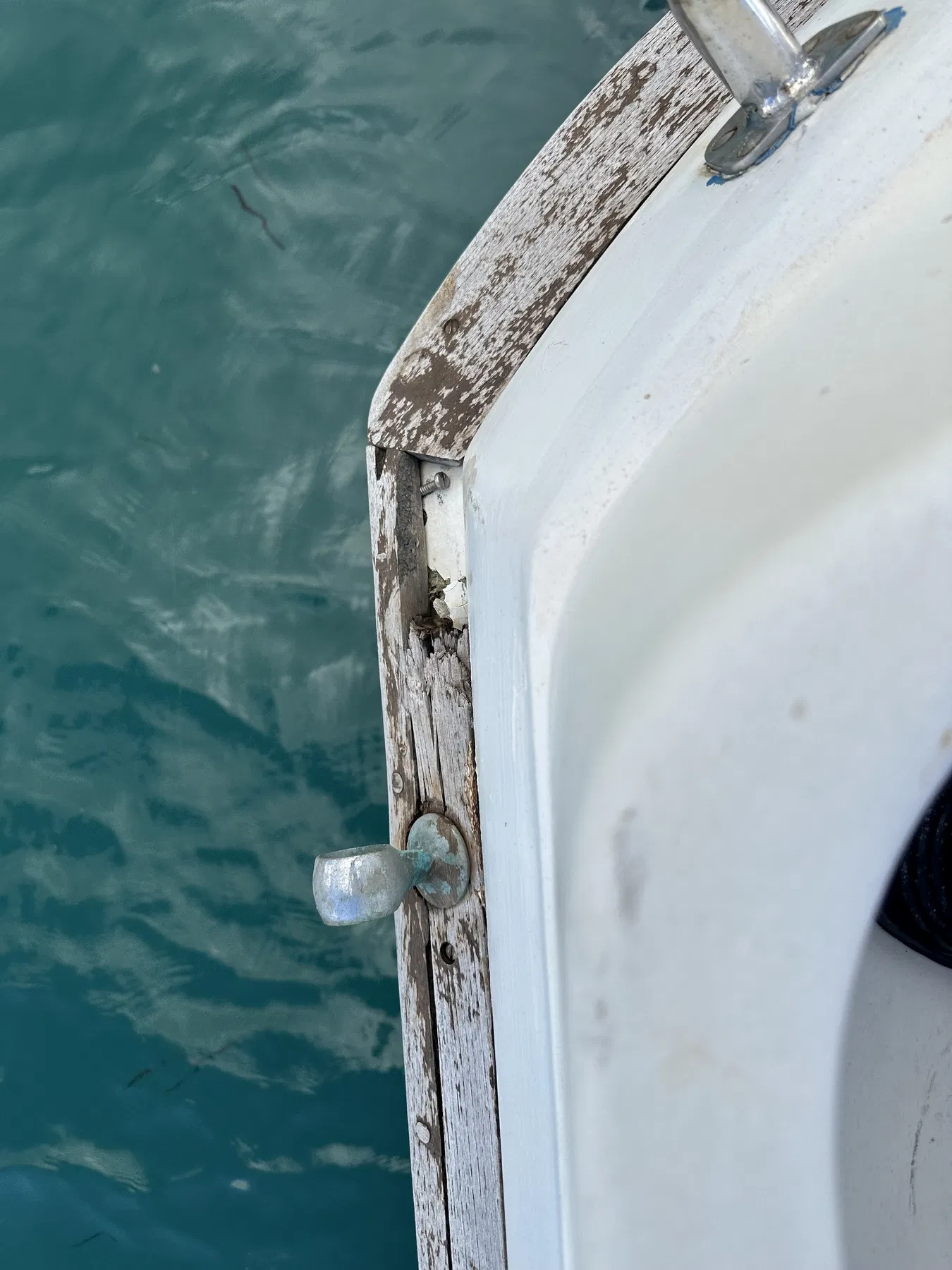 Geschädigtes Boot SANKARA – Deckskante mit Beschlag, Schrauben und sichtbarem Zustand des Holzes.