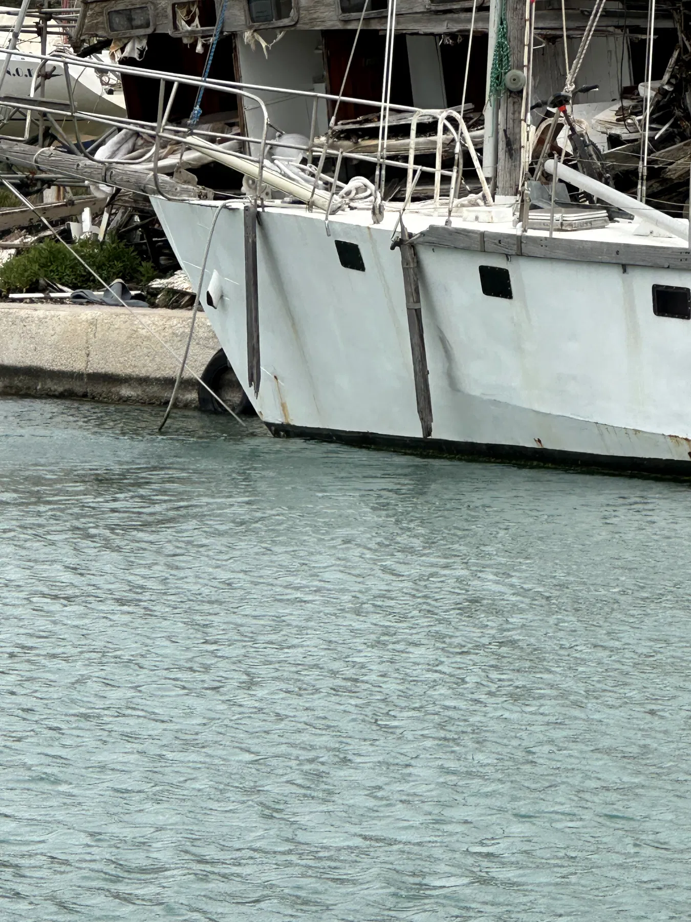 Verursacherboot NAUSICAA – Seitenansicht des deutlich größeren Rumpfes nahe der Kaimauer; Rumpfform, Fenster und äußere Verstärkungsleisten sind sichtbar.
