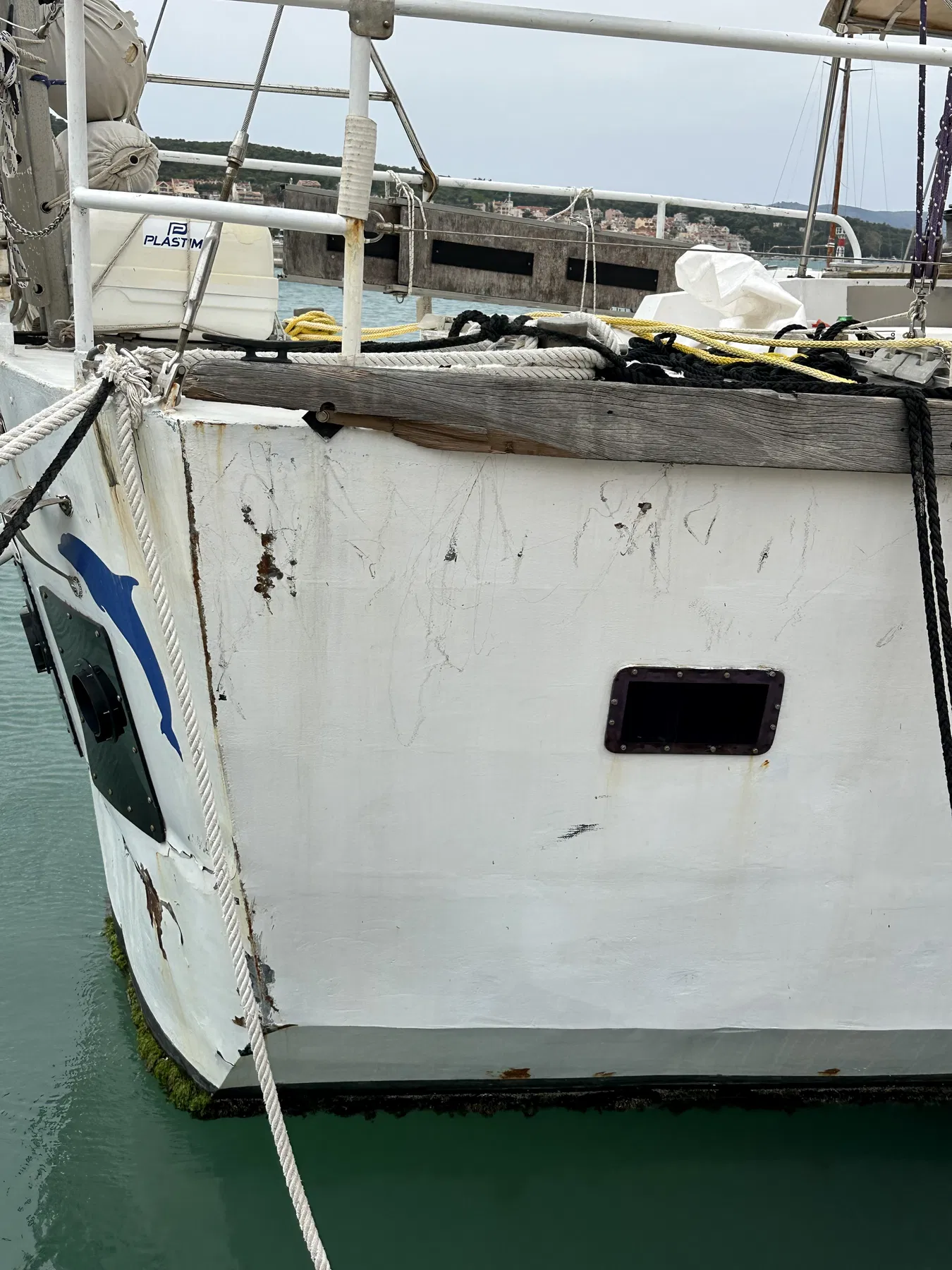 Verursacherboot NAUSICAA – Seitlicher Rumpfabschnitt mit Fenster, Leinen und Reifenfender.