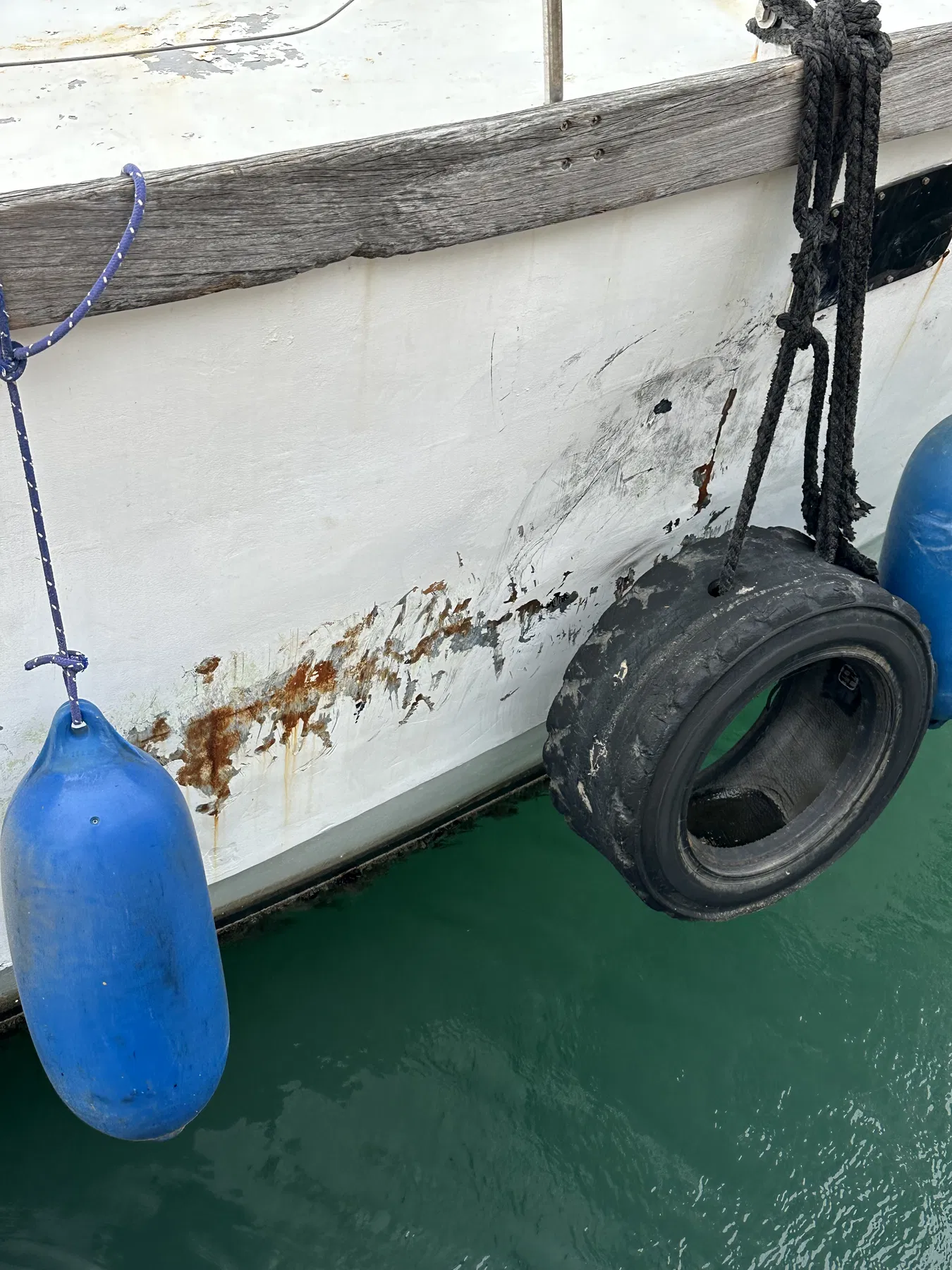 Verursacherboot NAUSICAA – Nahaufnahme der Rumpfoberfläche neben einem Reifenfender.